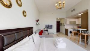 a living room with a large bed and a kitchen at Beautiful Studio Apartment Near New Dubai Mall I Balcony I Parking I Wifi I Furnished rooms in Dubai