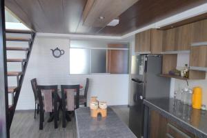 a kitchen with a table and chairs and a refrigerator at Departamento 3 niveles- Vista Panoramica 360 grados a toda la ciudad y Lago Titicaca in Puno