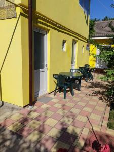 a patio with two benches and a table in front of a building at vila catrini in Costinesti