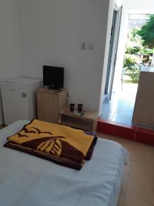 a bedroom with a bed with a blanket on it at vila catrini in Costinesti +3 photos