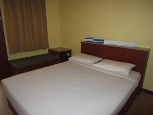 a bedroom with a large white bed and two benches at Sunset Beach Resort in Pantai Cenang