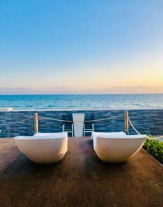 deux bateaux blancs assis sur une table près de l'océan dans l'établissement SUITEBEACH b&b and resort, à Marsala