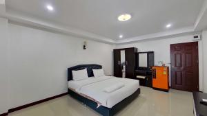 a bedroom with a white bed and a brown door at Grand Airport Resort in Lat Krabang