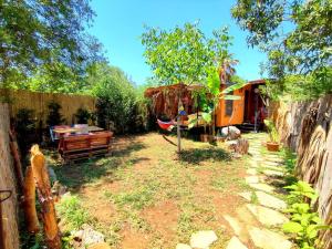 a backyard with a tent and a hammock at Tiny House Ceviz Kayaköy Jungle Camping in Fethiye