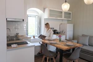 a woman sitting at a table in a kitchen at Metochi Athentic Hospitality in Hydra +20 photos