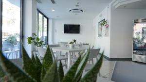 Un comedor con mesas blancas y sillas blancas. en Lively Hotel, en Bellaria-Igea Marina