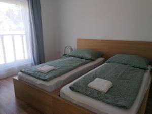 two twin beds in a room with a window at Sóstói Strand Apartmanház in Siófok