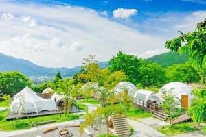 een uitzicht op een resort met tenten en bomen bij The Village Yufuin Onsen Glamping in Yufu