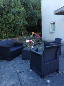 two chairs and a table with flowers on a patio at Ferienwohnung Dorfperle in Bad Mergentheim