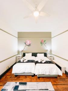 1 dormitorio con 1 cama y ventilador de techo en Aviators Club, en Port Alfred