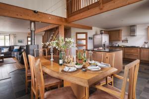 una cucina e una sala da pranzo con tavolo e sedie in legno di Beech Tree House a Saint Martins Green
