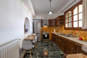 a kitchen with wooden cabinets and a table and a counter at A&S Seaside House in Lixouri