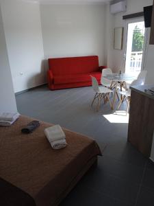 un soggiorno con divano rosso e tavolo di Athitos Cozy Studios ad Áfitos