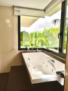 a large bath tub in a bathroom with a window at Grandes apartamentos de lujo en una casa con piscina en Javea in Montgo