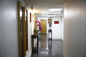 a hallway with yellow doors and flowers on a table at Sandhu Guest House in Hong Kong