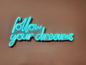 a neon sign that says follow your dreams at Adream in Pescara
