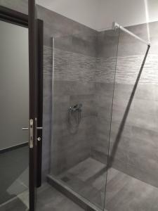 una doccia con porta in vetro in bagno di Athitos Cozy Studios ad Áfitos