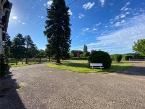 a park with a bench next to a tree at La Ferrière in Pissy-Pôville +9 photos