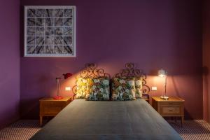 ein Schlafzimmer mit einem großen Bett mit lila Wänden in der Unterkunft Frangimare La Segreta in Malfa