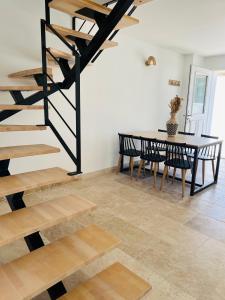 a dining room with a table and a spiral staircase at Résidence L’Oiseau des Sables in Saintes-Maries-de-la-Mer