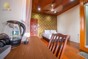 um quarto com uma cama e uma mesa com um liquidificador em Flypod . Kinabalu Mt Lodge em Ranau