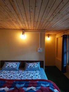 a bedroom with a bed with a wooden ceiling at NotOnMap- Amaira Homestay in Khajjiar 