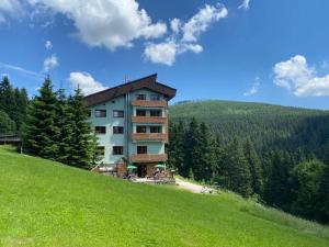 a building on the side of a hill with trees at Cihlářka - Apartmán 309 in Pec pod Sněžkou