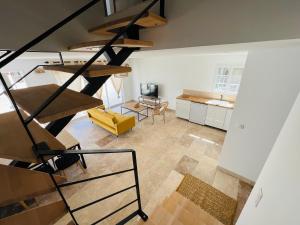 a living room with a spiral staircase in a loft at Résidence L’Oiseau des Sables in Saintes-Maries-de-la-Mer