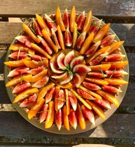 un plato de frutas y hortalizas en una mesa en HôTEL LES VOLETS ROUGES - CASSIS, en Cassis