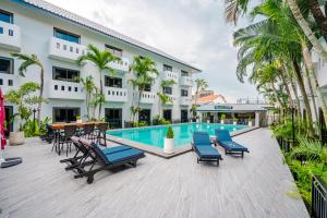 a resort with a swimming pool and chairs and a hotel at DEL MAX Resort Pattaya in Pattaya South
