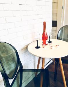 a table with two glasses and a bottle on it at Apartament nad Pisą in Pisz