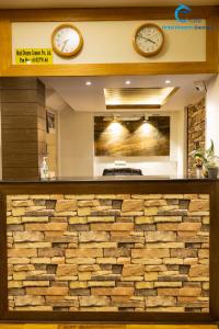 two clocks on the wall above a stone counter at Hotel Dreams connect GRB in Kathmandu