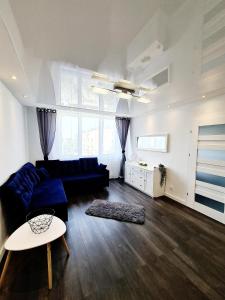 a living room with a blue couch and a table at Apartament nad Pisą in Pisz