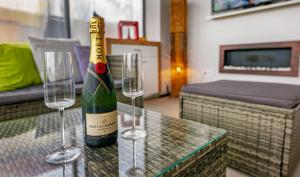 a bottle of champagne and two wine glasses on a table at Villa46 in Pécs