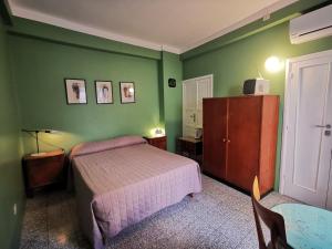 1 dormitorio con paredes verdes, 1 cama y 1 mesa en Casa Farella B&B in mini Apartments Altamura x Matera, en Altamura