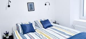 Una cama con almohadas azules en una habitación blanca. en APARTMA GALEB, en Piran