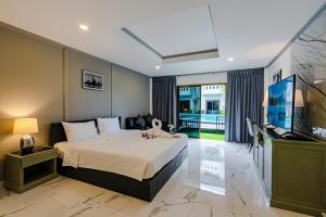 a bedroom with a bed and a flat screen tv at DEL MAX Resort Pattaya in Pattaya South +148 photos