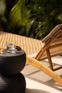 einen Tisch mit einem Getränk und einem Glas darüber in der Unterkunft Villa Casa Orana in Seminyak
