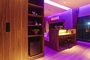 a purple room with a bar with a stool at The Weekend Pattaya (Tweet Tweet Nest Pattaya) in Pattaya