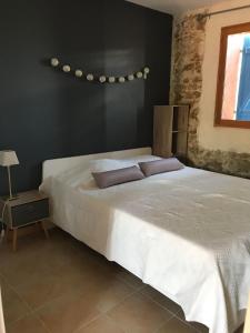 een slaapkamer met een wit bed en een zwarte muur bij O’gîtes des colombes in Colombiers