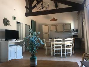 a kitchen and dining room with a table and chairs at O’gîtes des colombes in Colombiers