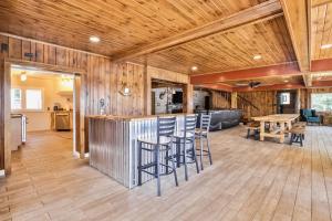 a kitchen and living room with a bar with stools at Timber Lodge Retreat in Rhinelander