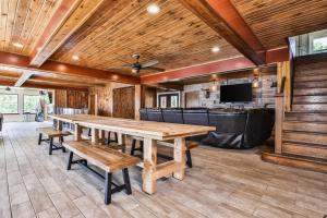 uma sala de jantar com uma grande mesa de madeira e bancos em Timber Lodge Retreat em Rhinelander