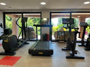 a gym with treadmills and exercise equipment in a room at Hotel Niedersächsischer Hof in Bad Bentheim