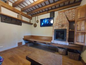 a living room with a fireplace and a tv at La Casuca de Agüero in Agüero