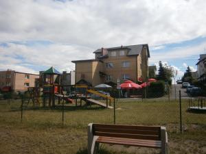 a park with a bench and a playground at Dom gościnny Krystyna in Władysławowo