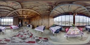 a dining room with tables and chairs and windows at Cappadocia Alaz Cave Otel in Nevşehir