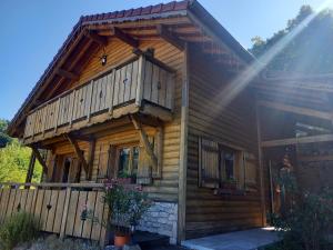 Cette cabane en rondins dispose d'un balcon sur le côté. dans l'établissement Chalet Typique Vosgien "les Barbotines", à Ventron