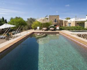 een groot zwembad met blauw water in een tuin bij Hotel Rural Can Partit - Adults Only in Santa Agnès de Corona