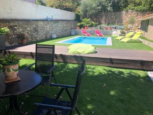 a yard with a table and chairs and a pool at Villa calme avec piscine privée nimes in Nîmes